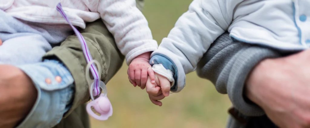 Zwei Babys halten Händchen